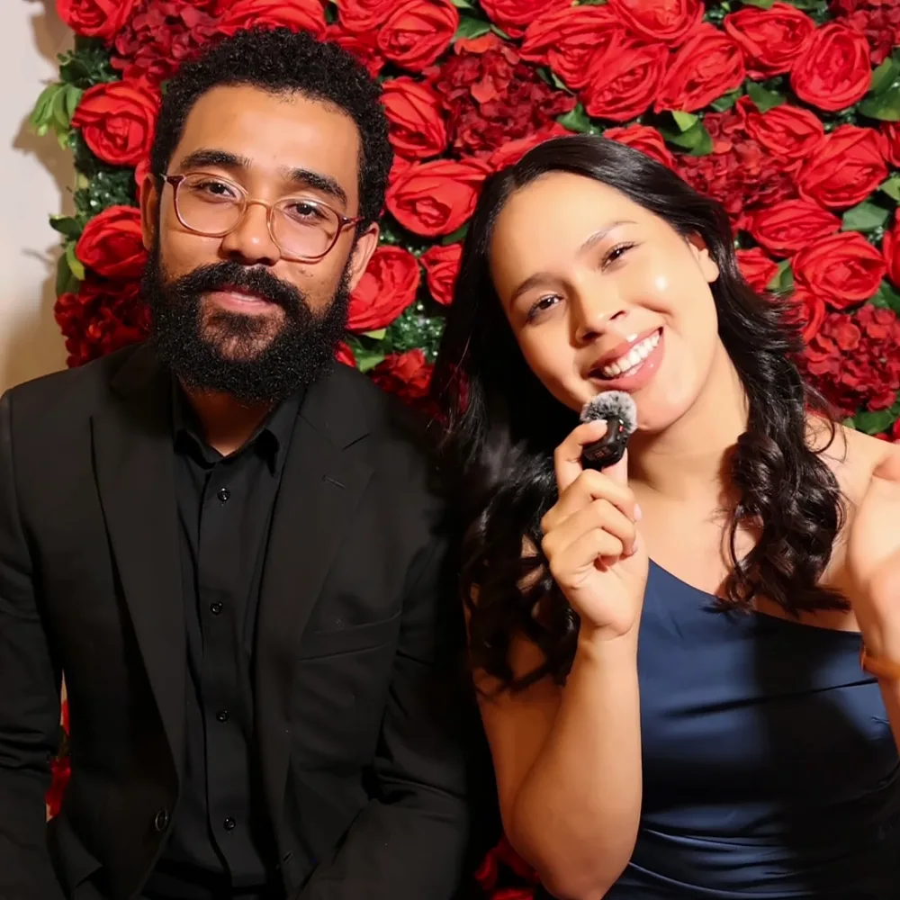 Couple laughing together while recording a Confessional Booth video message